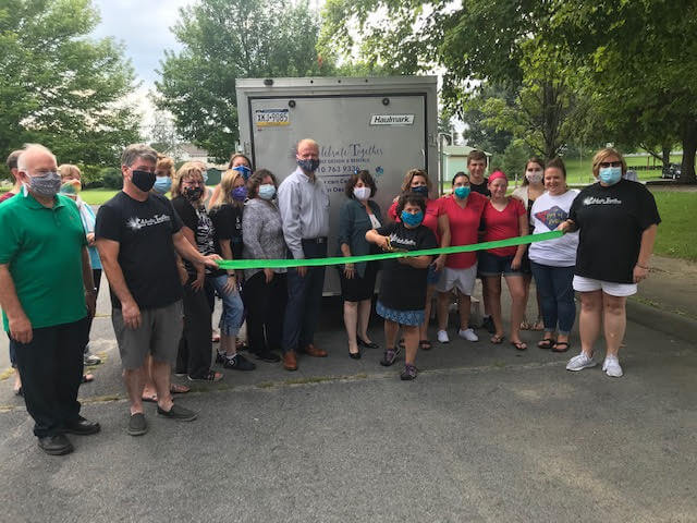 ribbon cutting near a trailer and park